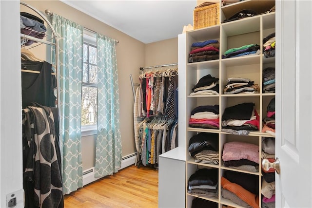 spacious closet featuring baseboard heating and wood finished floors