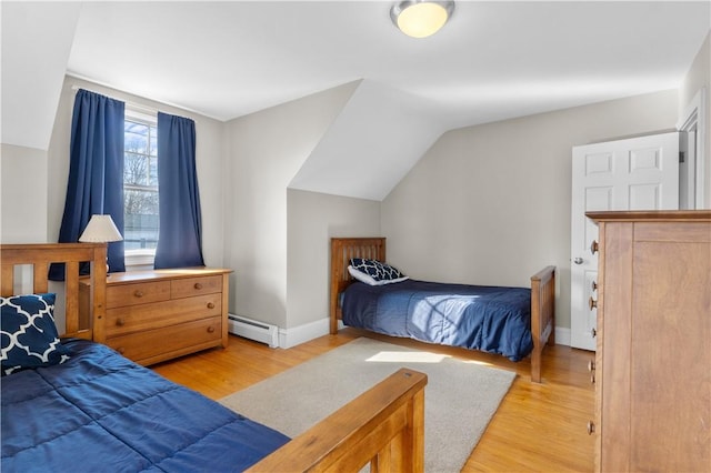 bedroom featuring light wood-style flooring, a baseboard heating unit, vaulted ceiling, and baseboards