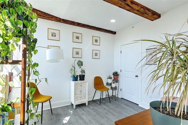 living area featuring beamed ceiling, recessed lighting, wood finished floors, and baseboards