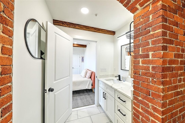 bathroom with brick wall, ensuite bath, and vanity