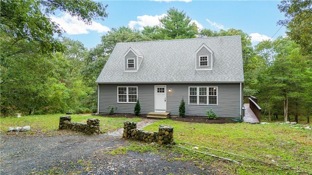 new england style home with a shingled roof and a front yard