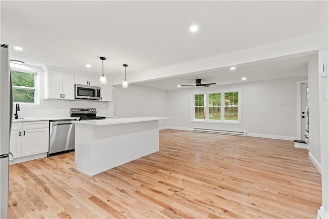 kitchen featuring light wood-style flooring, a center island, baseboard heating, stainless steel appliances, and white cabinetry