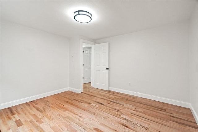 unfurnished room with baseboards and light wood-style floors