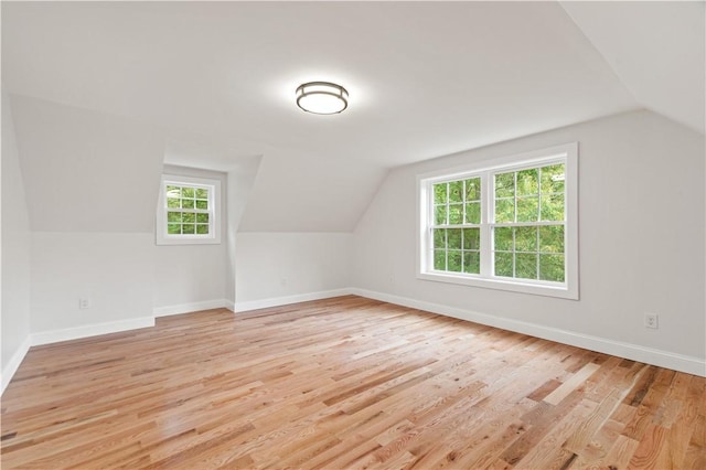 bonus room with lofted ceiling, light wood-style flooring, and baseboards