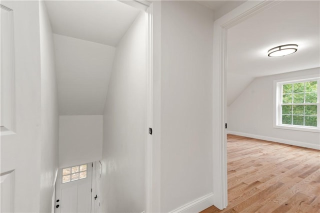 interior space featuring vaulted ceiling, wood finished floors, and baseboards