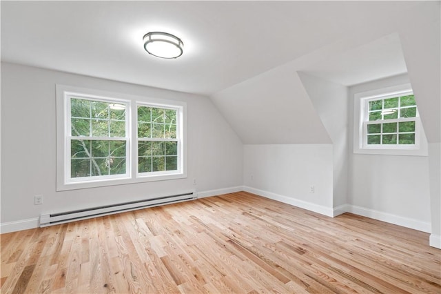 bonus room featuring baseboards, a baseboard heating unit, vaulted ceiling, and wood finished floors