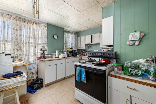 kitchen featuring light countertops, white cabinetry, range with electric stovetop, and light floors