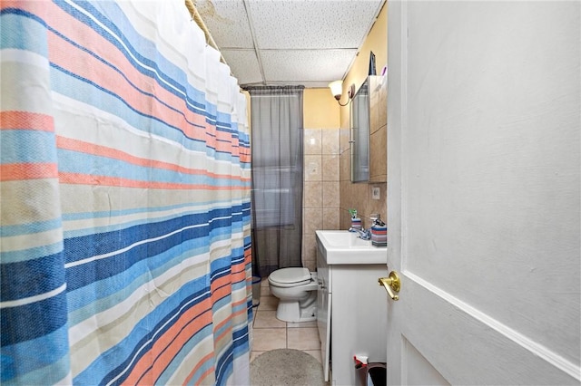 full bath featuring a paneled ceiling, toilet, vanity, a shower with curtain, and tile patterned floors