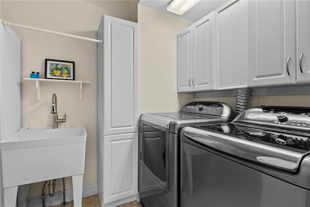 washroom with cabinet space, a sink, and independent washer and dryer