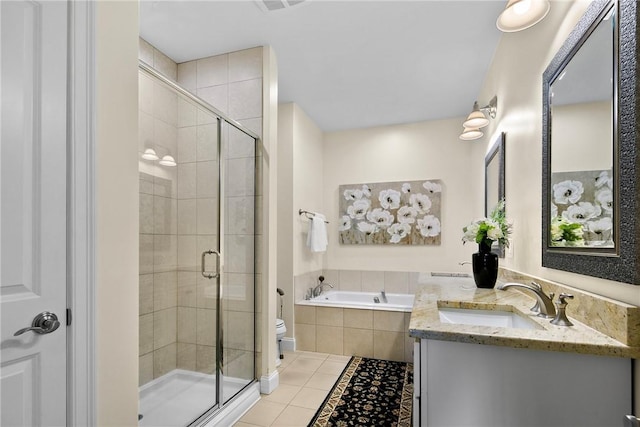 full bathroom featuring a stall shower, tile patterned flooring, a garden tub, and vanity