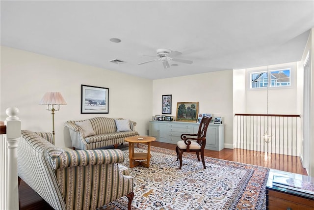 living area with ceiling fan, wood finished floors, and visible vents