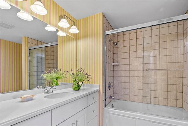 bathroom featuring wallpapered walls, visible vents, bath / shower combo with glass door, and vanity