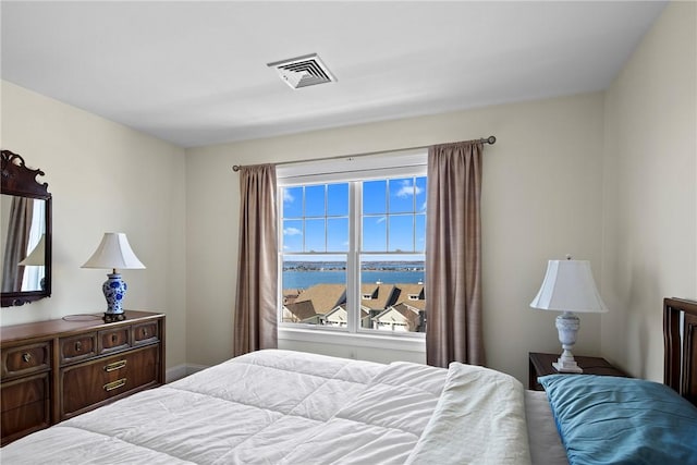 bedroom with a water view and visible vents