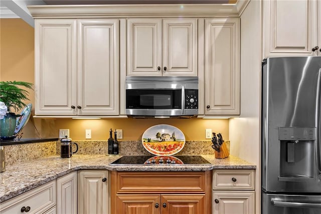 kitchen with white cabinetry, appliances with stainless steel finishes, and light stone counters