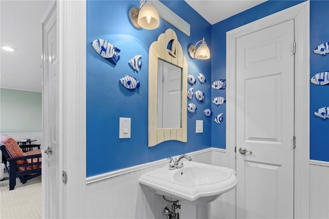 bathroom with a wainscoted wall and a sink