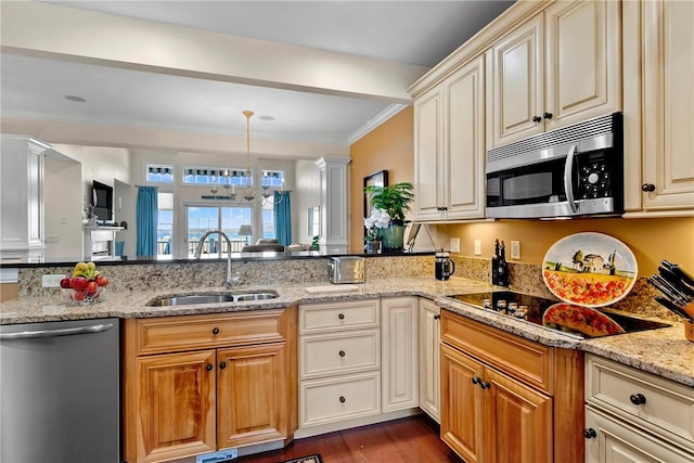 kitchen featuring appliances with stainless steel finishes, light stone countertops, crown molding, ornate columns, and a sink