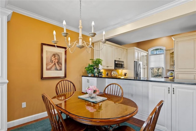 dining area with decorative columns, a chandelier, crown molding, and wood finished floors