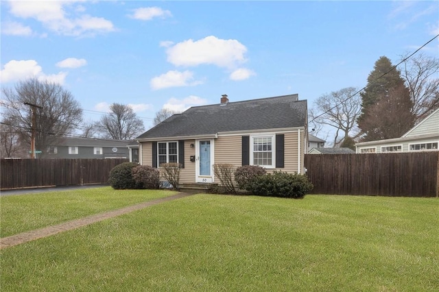 bungalow with a shingled roof, a front yard, fence, and a chimney