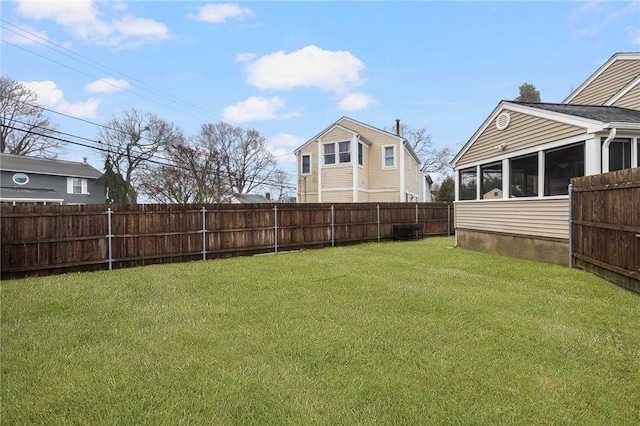 view of yard with a fenced backyard and a sunroom