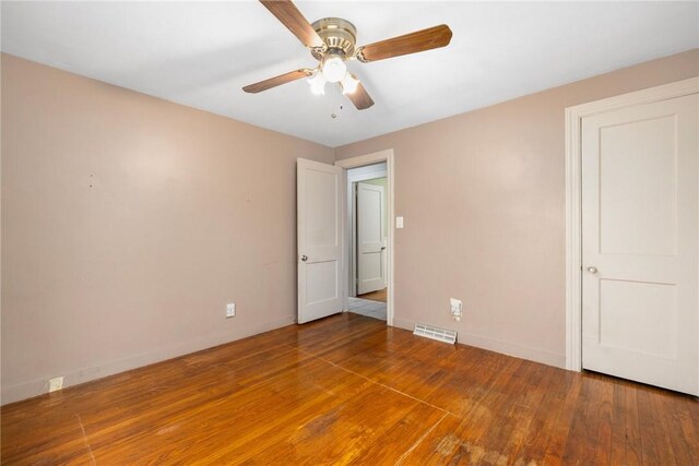 unfurnished bedroom featuring visible vents, baseboards, wood finished floors, and a ceiling fan