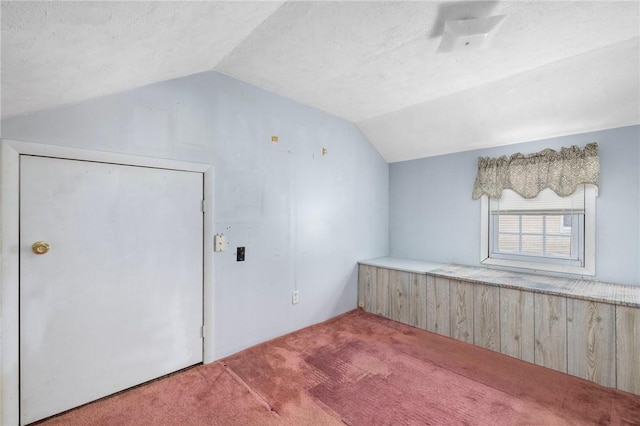 bonus room featuring a textured ceiling, carpet, and vaulted ceiling