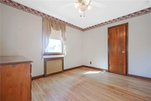 empty room with ceiling fan, light wood-style flooring, and baseboards