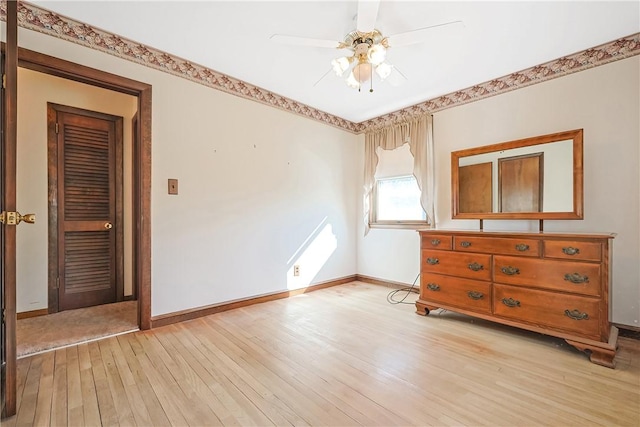 unfurnished bedroom featuring light wood-style floors, baseboards, and a ceiling fan