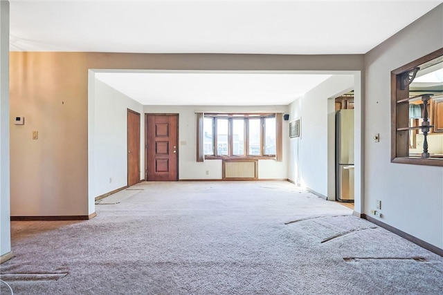 unfurnished room with light carpet, radiator heating unit, and baseboards