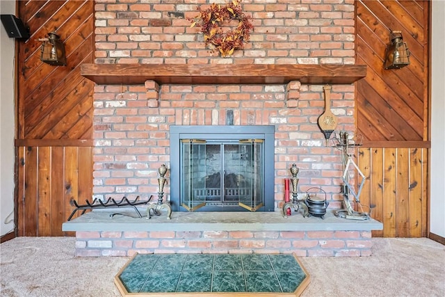 interior details with carpet flooring, a fireplace, and wood walls