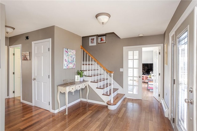 foyer with a healthy amount of sunlight, stairway, wood finished floors, and french doors