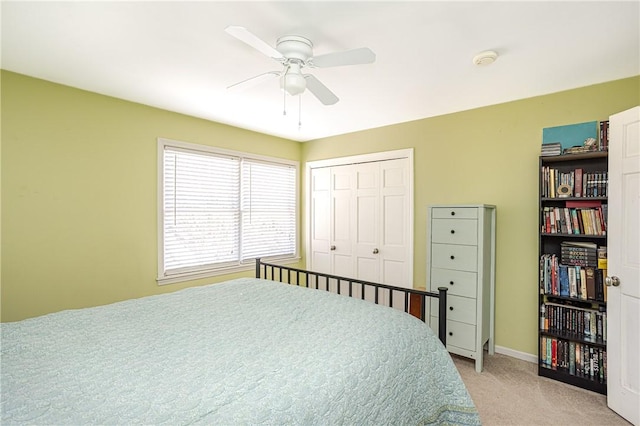 bedroom with light carpet, ceiling fan, and a closet