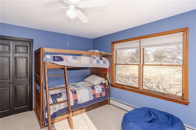 carpeted bedroom featuring ceiling fan and a baseboard heating unit