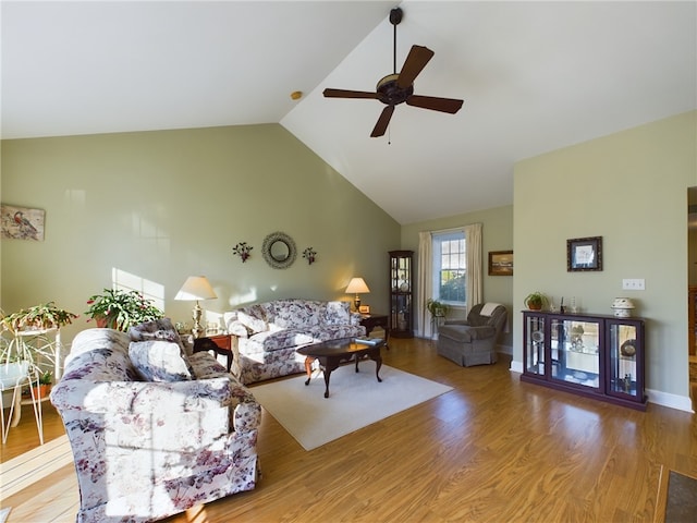 living area with high vaulted ceiling, wood finished floors, a ceiling fan, and baseboards