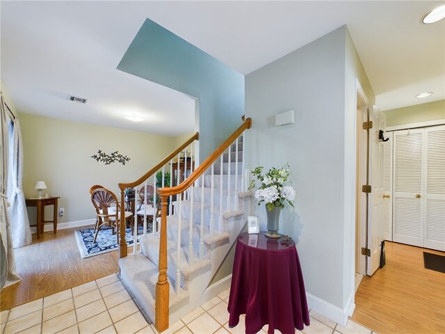 staircase featuring visible vents, baseboards, and wood finished floors