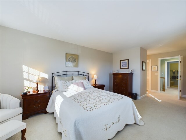 bedroom featuring light carpet and baseboards