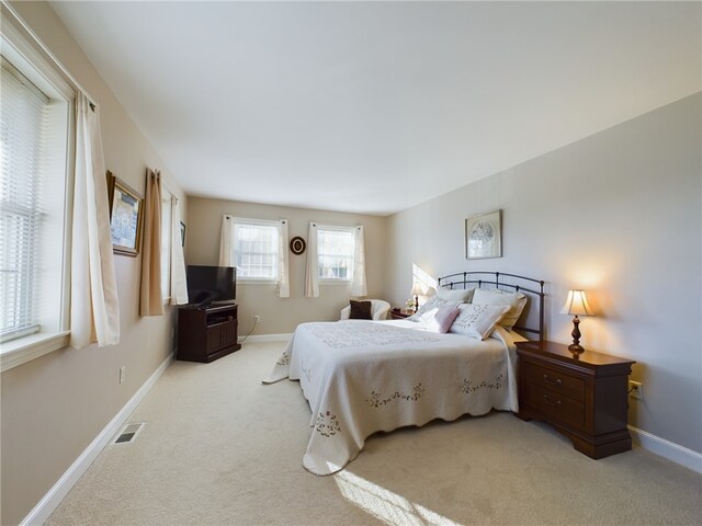 carpeted bedroom with visible vents and baseboards