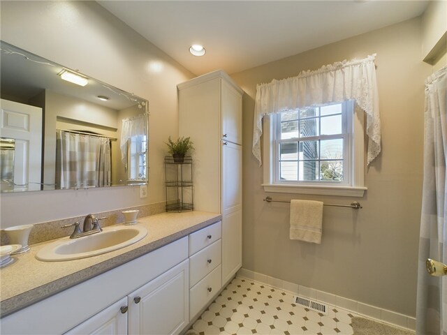 bathroom with baseboards, visible vents, a shower with shower curtain, vanity, and recessed lighting