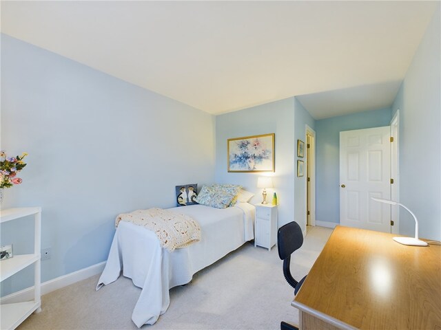 bedroom with baseboards and light colored carpet