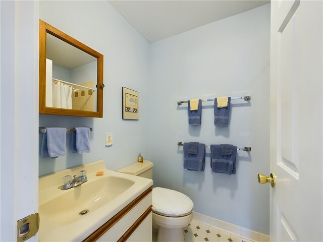 full bath featuring vanity, toilet, and baseboards