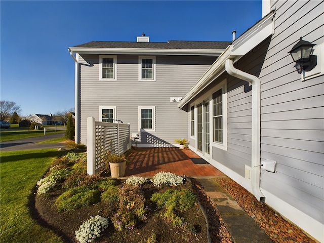 rear view of property featuring a yard and a deck