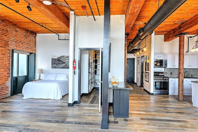 bedroom with wood ceiling, beam ceiling, and wood finished floors