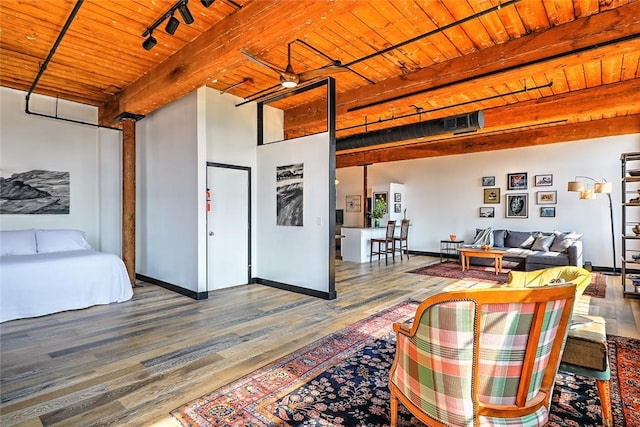 interior space featuring baseboards, wood ceiling, beamed ceiling, wood finished floors, and rail lighting