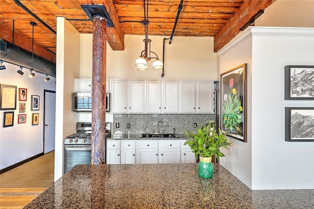 kitchen featuring wooden ceiling, stainless steel appliances, a sink, tasteful backsplash, and beamed ceiling