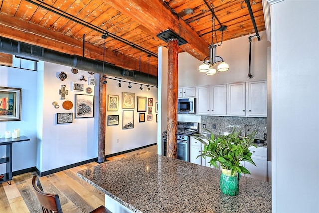 kitchen with decorative backsplash, wood ceiling, light wood-style flooring, appliances with stainless steel finishes, and beamed ceiling