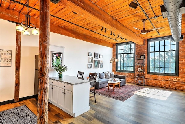 interior space with wood ceiling, brick wall, wood finished floors, and beamed ceiling