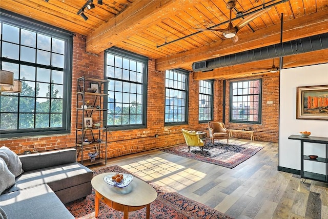 living room with wood ceiling, brick wall, beamed ceiling, wood finished floors, and track lighting