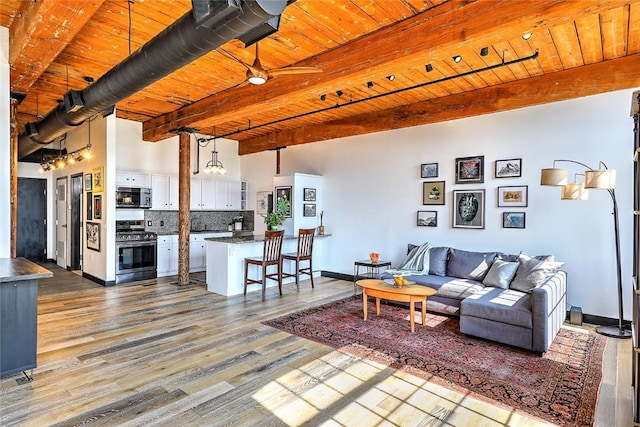 living area featuring wood ceiling, baseboards, beam ceiling, and wood finished floors