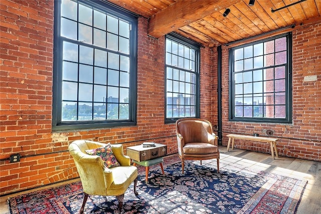 sitting room featuring a high ceiling, wood ceiling, brick wall, beamed ceiling, and hardwood / wood-style floors