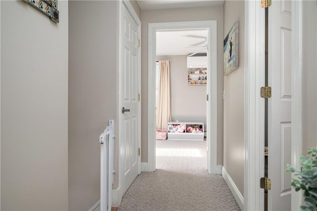 hallway featuring carpet and baseboards