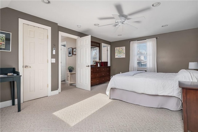 carpeted bedroom with ceiling fan and baseboards